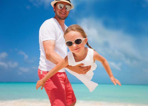 Girl playing on beach with father